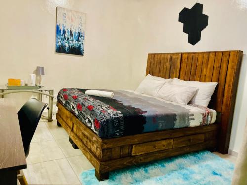a bedroom with a wooden bed in a room at SapzRes at Klerksdorp in Klerksdorp