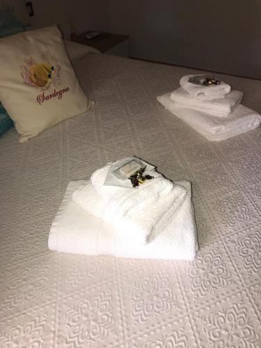 two towels and a bag on a bed at La fragola in Campagna 6 k m da San pantaleo in San Pantaleo