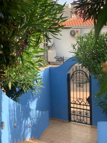 a blue gate in front of a house with plants at Maroccana in Dobra Voda
