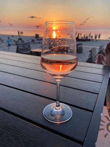 a glass of wine sitting on a table near the beach at Villa Bella Elana in Jūrmala