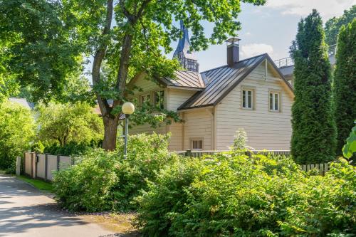 a yellow house with a gambrel roof at Villa Bella Elana in Jūrmala