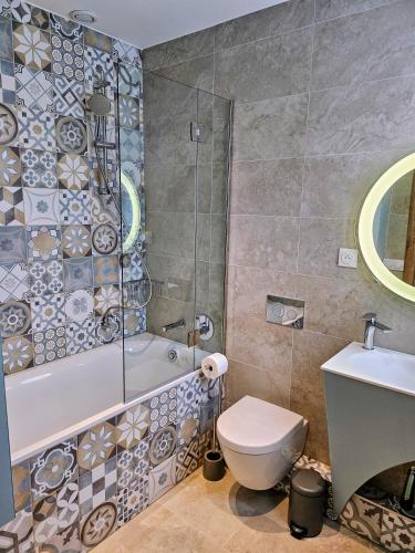 une salle de bain avec une baignoire, des toilettes et un lavabo dans l'établissement Charmant studio près de la plage avec jacuzzi et terrasse privative, à Villeneuve-Loubet