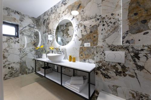 a bathroom with a sink and a mirror at Holiday Home Izzy in Kaštela
