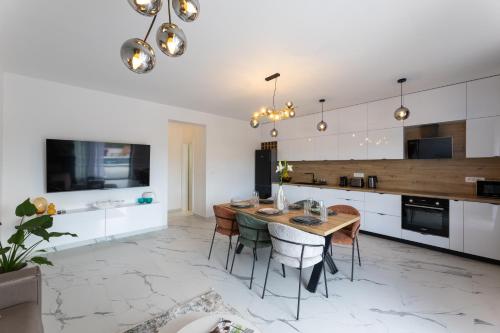 a kitchen and dining room with a table and chairs at Holiday Home Izzy in Kaštela