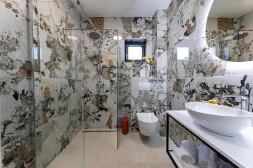a bathroom with a sink and a glass shower at Holiday Home Izzy in Kaštela