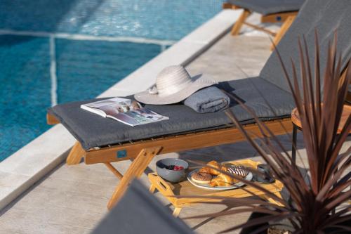 a table with a hat and a plate of food next to a pool at Holiday Home Izzy in Kaštela