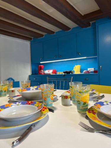 une table de salle à manger avec des assiettes et des verres dessus dans l'établissement Le Campagnard vintage Bourguignon, à Saint-Privé