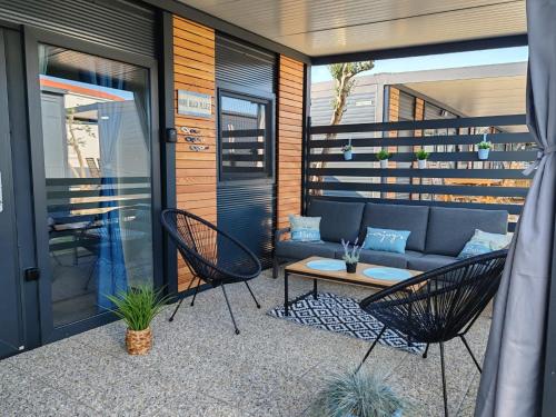a patio with a couch and chairs and a table at EMMI Mobile Home in Sveti Petar