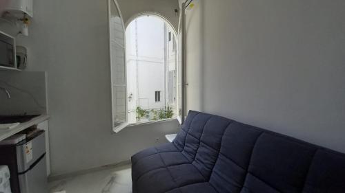 un salon avec un canapé bleu et une fenêtre dans l'établissement Winter Palace Beauséjour, à Cannes