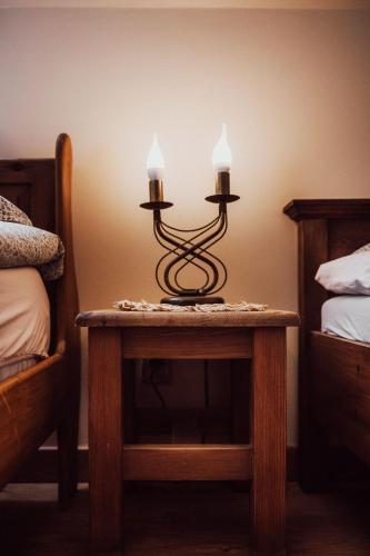 a table with two candles on it next to two beds at KrokusChata pod Sokolicą in Krościenko