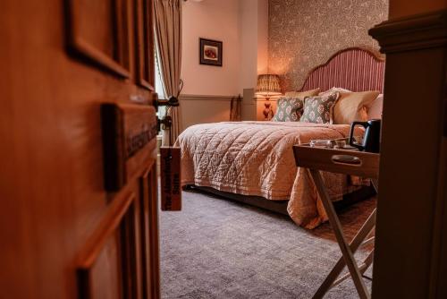 a bedroom with a bed and a table with a drawer at The Ashford Arms in Bakewell