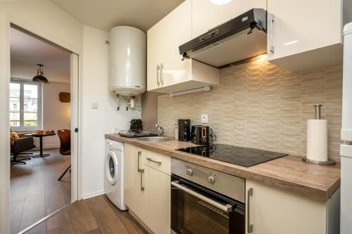 Il comprend une cuisine équipée d'un évier et d'un lave-linge/sèche-linge. dans l'établissement Le 37-GregIMMO-Appart'Hôtel, à Belfort