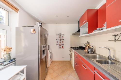 a kitchen with red cabinets and a stainless steel refrigerator at Villa Bella Elana in Jūrmala