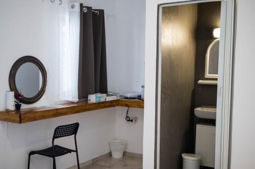 a bathroom with a black chair and a mirror at G&A Rooms Marmari in Marmari