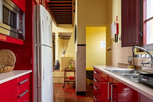 a kitchen with red cabinets and a sink at Casa do Cerco in Água de Pau