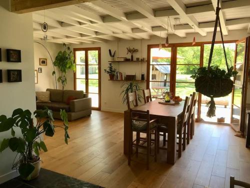 un salon avec une table et des chaises de salle à manger dans l'établissement Délicieuse maison landaise lumineuse et cosy, à Soustons