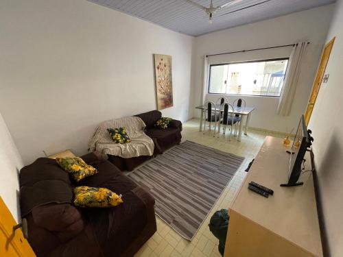 a living room with two couches and a table at Casa Praia Grande in Praia Grande