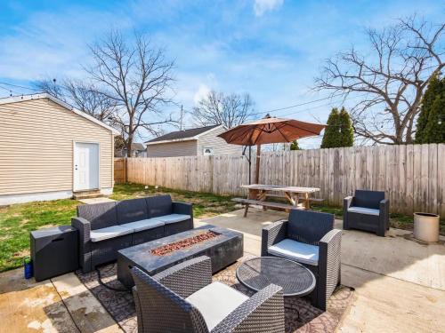 a patio with a table and chairs and an umbrella at Urban Oasis w Hot Tub Near Downtown & Arena District in Columbus