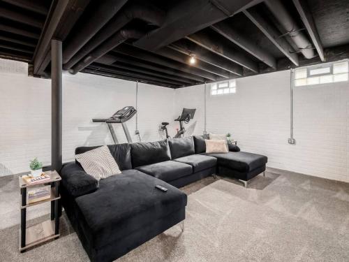 a living room with a black couch and a table at Urban Oasis w Hot Tub Near Downtown & Arena District in Columbus