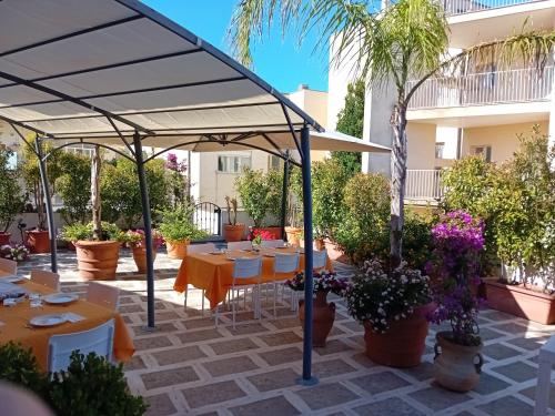 a patio with tables and chairs under a canopy at Mediterraneo B&B in Maglie