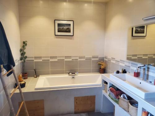 La salle de bains est pourvue d'une baignoire et de 2 lavabos. dans l'établissement Grande maison savoyarde ensoleillée, à Villard-sur-Boëge