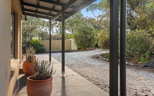 a patio with two potted plants on a porch at The Purple Door on Seaview in Victor Harbor