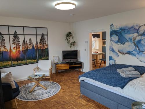 a bedroom with a bed and a tv and a table at Wallfried #2 Ferien- und Business Appartement Bayreuth in Bayreuth