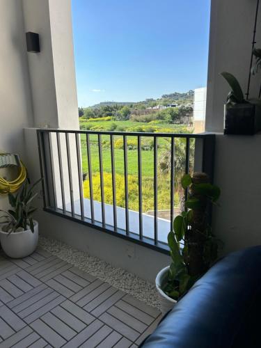 a balcony with a view of a field of flowers at Hortensia rooms in St Paul's Bay