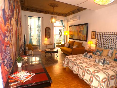 ein Wohnzimmer mit einem Bett und einer Couch in der Unterkunft Boutique Carthago Modernista Experiencias CarthagoTematizadas in Cartagena