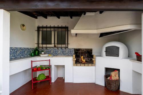 a model kitchen with a stove and a fireplace at Casa da Vigia - Santa Cruz - Casa com Jardim a 4 Min da Praia in A dos Cunhados