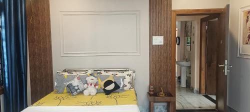 a bedroom with a bed with two teddy bears on it at Riverside Palm Luxe 2BHK with AC in both bedrooms near Kamakhya & IHR in Guwahati
