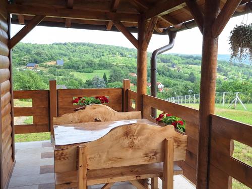 a wooden porch with a table and a view at Brvnara Beni in Vrdnik