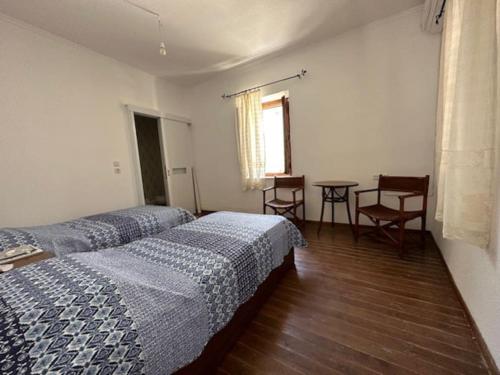 a bedroom with two beds and a table and chairs at Old Town Traditional House in Kos Town