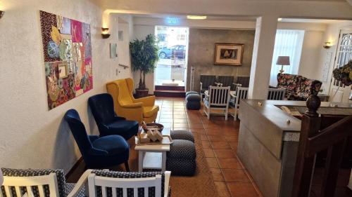 a waiting room with colorful chairs and a counter at Hotel Central Jardim in Geres