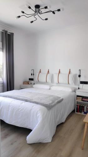 a bedroom with a large white bed with a chandelier at Valdoviño Experience in Valdoviño