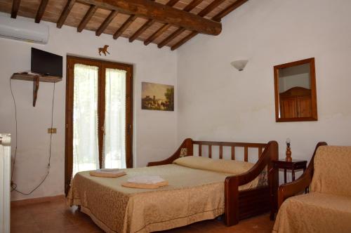 sypialnia z łóżkiem, kanapą i oknem w obiekcie Agriturismo "La Fraschetta" w mieście Bolsena