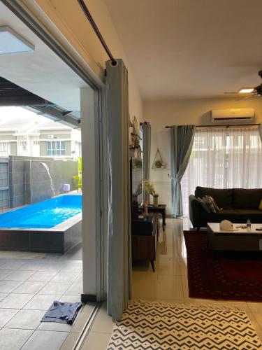 a living room with a view of a swimming pool at Araas Boutique House for Family Stay ONLY in Sungai Buluh