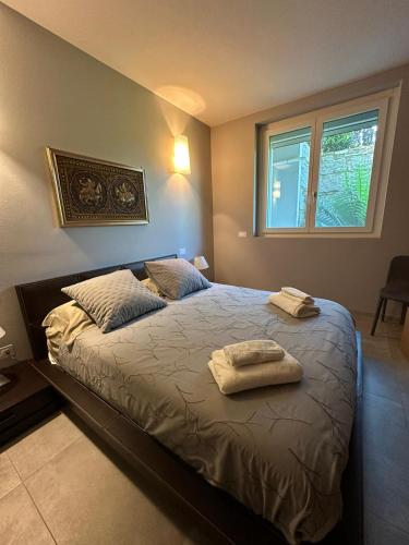 a bedroom with a bed with two towels on it at Suite Rose on the lake Arona in Meina