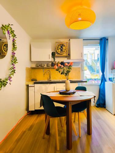 a kitchen with a table and chairs and a sink at Le King & Suites étoilées in Gréoux-les-Bains