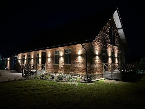 a brick building with lights on it at night at Stara Szkola - Wielki Medromierz 59 in Wielki Modromierz
