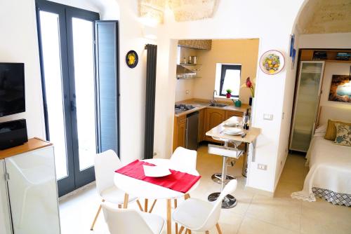 a kitchen with a table and chairs in a room at Dimora Le Vele - ELEGANZA con VISTA MARE in Ostuni