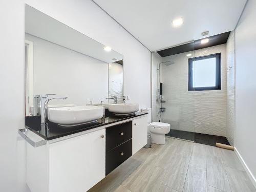een badkamer met 2 wastafels en een toilet bij Gertrudes Dream House in Ponta do Sol