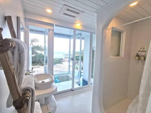 a bathroom with a tub and a sink and a window at Ample Villa 小希臘民宿 in Ruifang