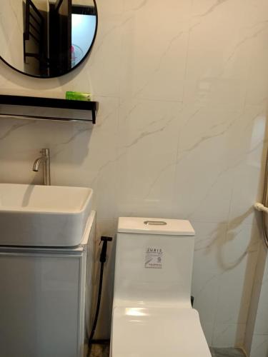 a bathroom with a white toilet and a sink at MGM Guest House in San Felix