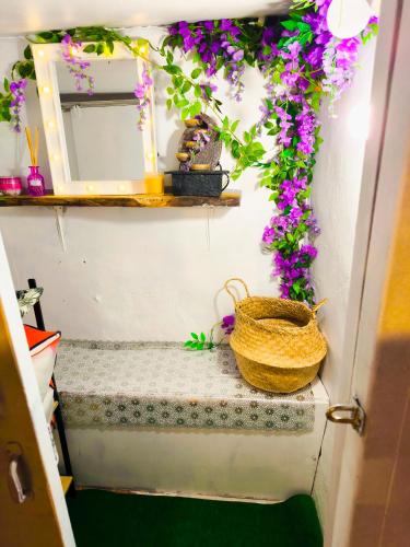 a door with a basket on a shelf with flowers at Le King & Suites étoilées in Gréoux-les-Bains