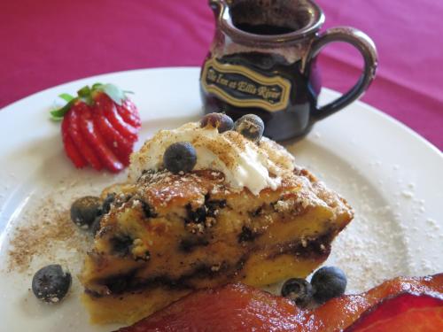 un piatto di cibo con una fetta di torta e una fragola di Inn at Ellis River a Jackson