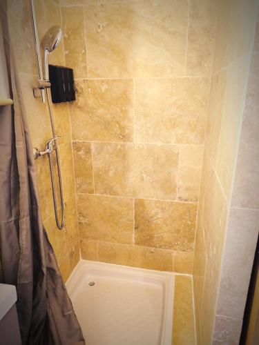 a shower in a bathroom with a tiled wall at Le King & Suites étoilées in Gréoux-les-Bains