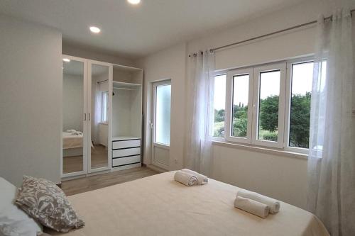 a bedroom with a large bed with two towels on it at Bungevilia Apartment in Gruda