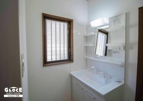 a white bathroom with a sink and a window at GLOCE 半原 River Side House ｌリバービュー1軒貸切ｌ最大8名ｌワンちゃんOK in Managura