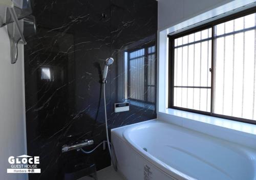 a bathroom with a bath tub and a window at GLOCE 半原 River Side House ｌリバービュー1軒貸切ｌ最大8名ｌワンちゃんOK in Managura